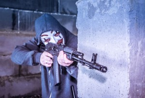 person with rifle wearing mask