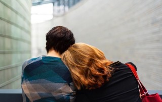 woman rests her shoulder on another person's shoulder