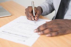 man signing documents