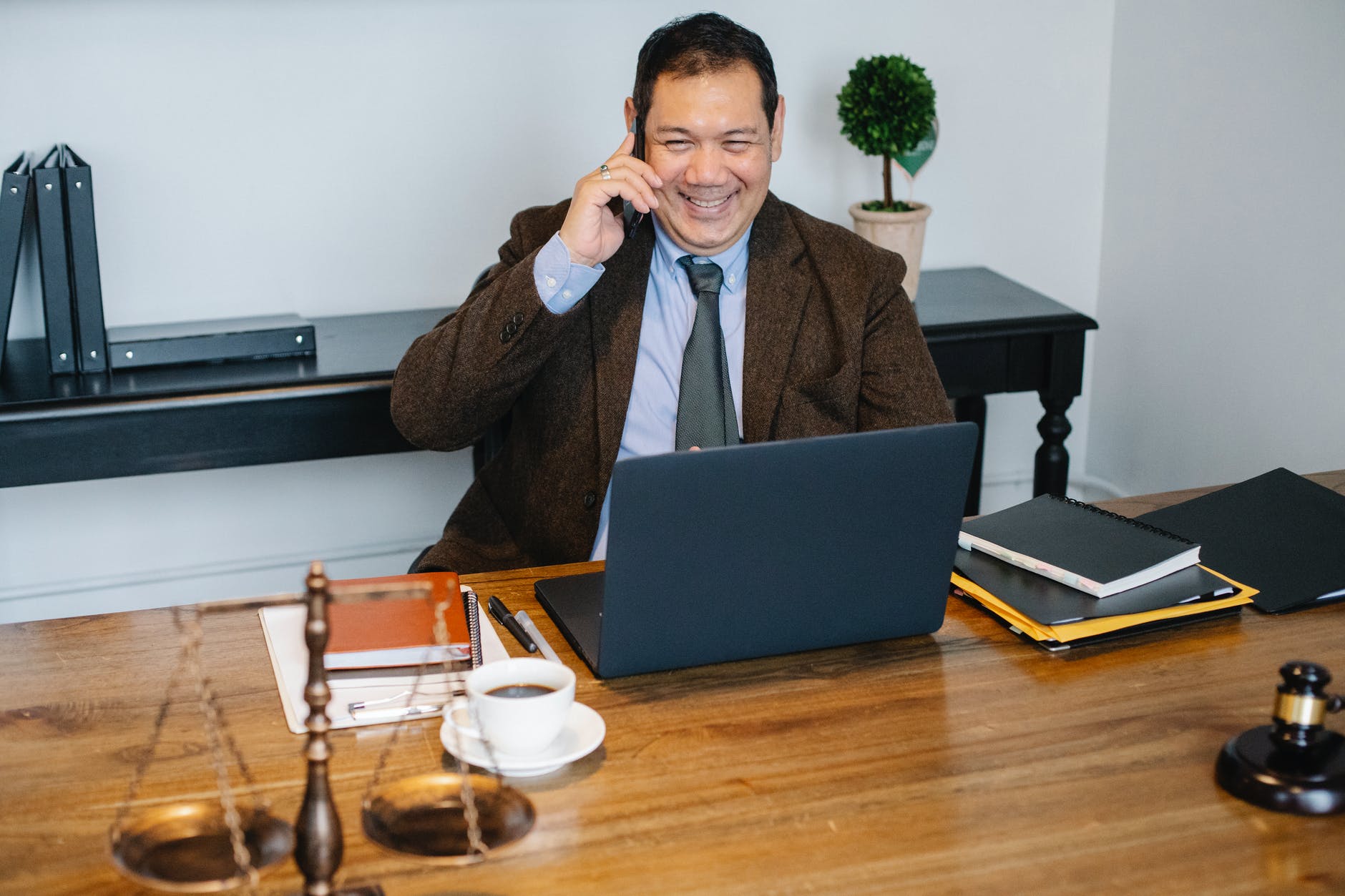 man smiling while using cellphone in office