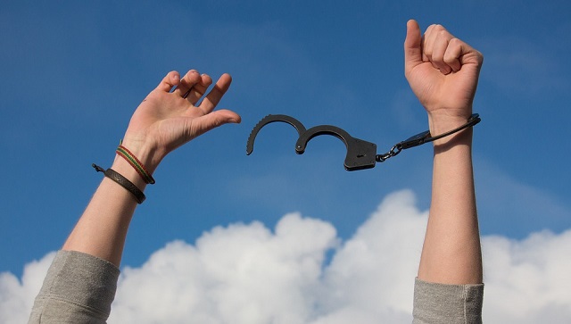 hands being liberated from handcuffs