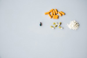 different types of pills and a pile of powder