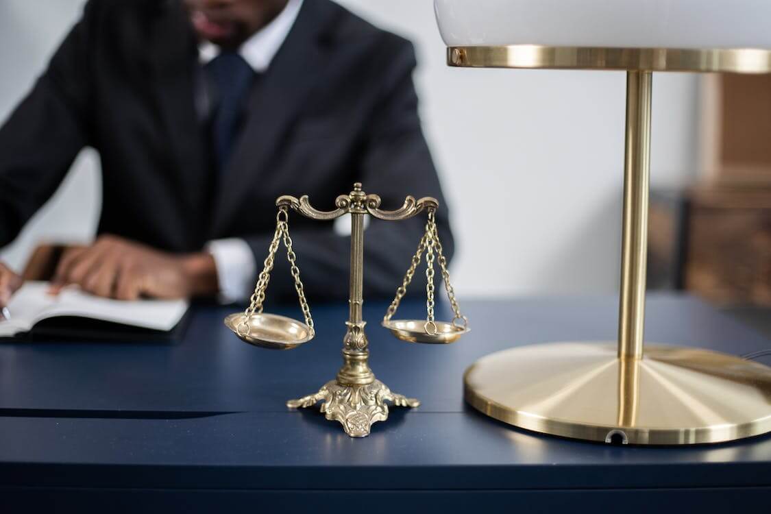 balance scale next to lamp on lawyer’s desk