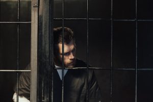 man standing behind bars