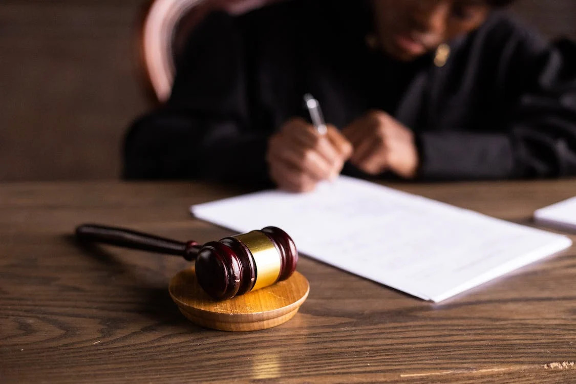 gavel sitting on desk as judge writes