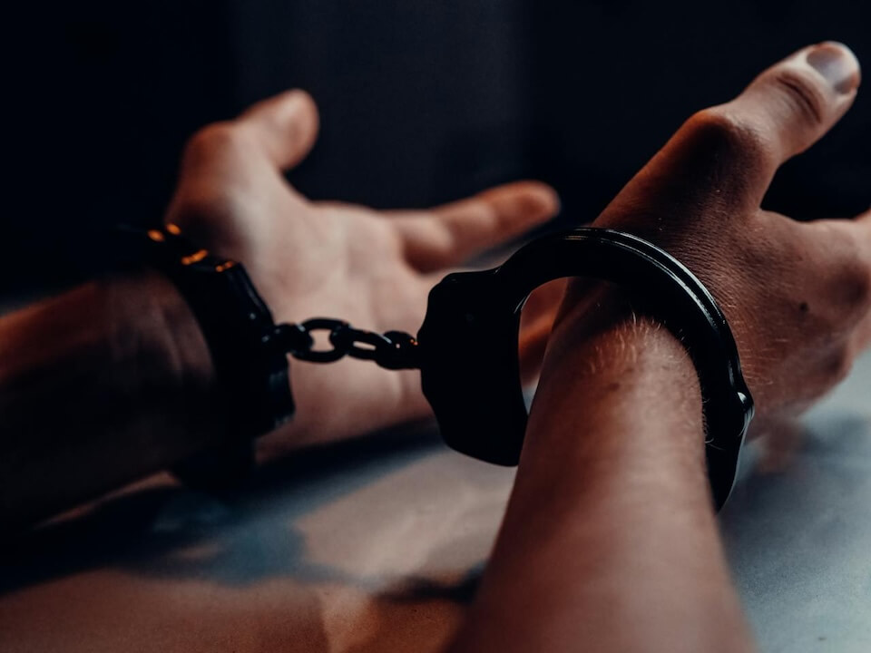 hands in handcuffs in dark room
