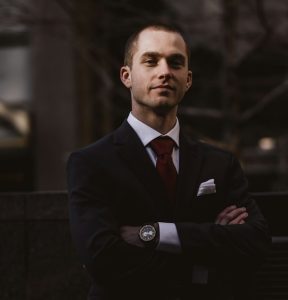 man in suit standing with arms crossed