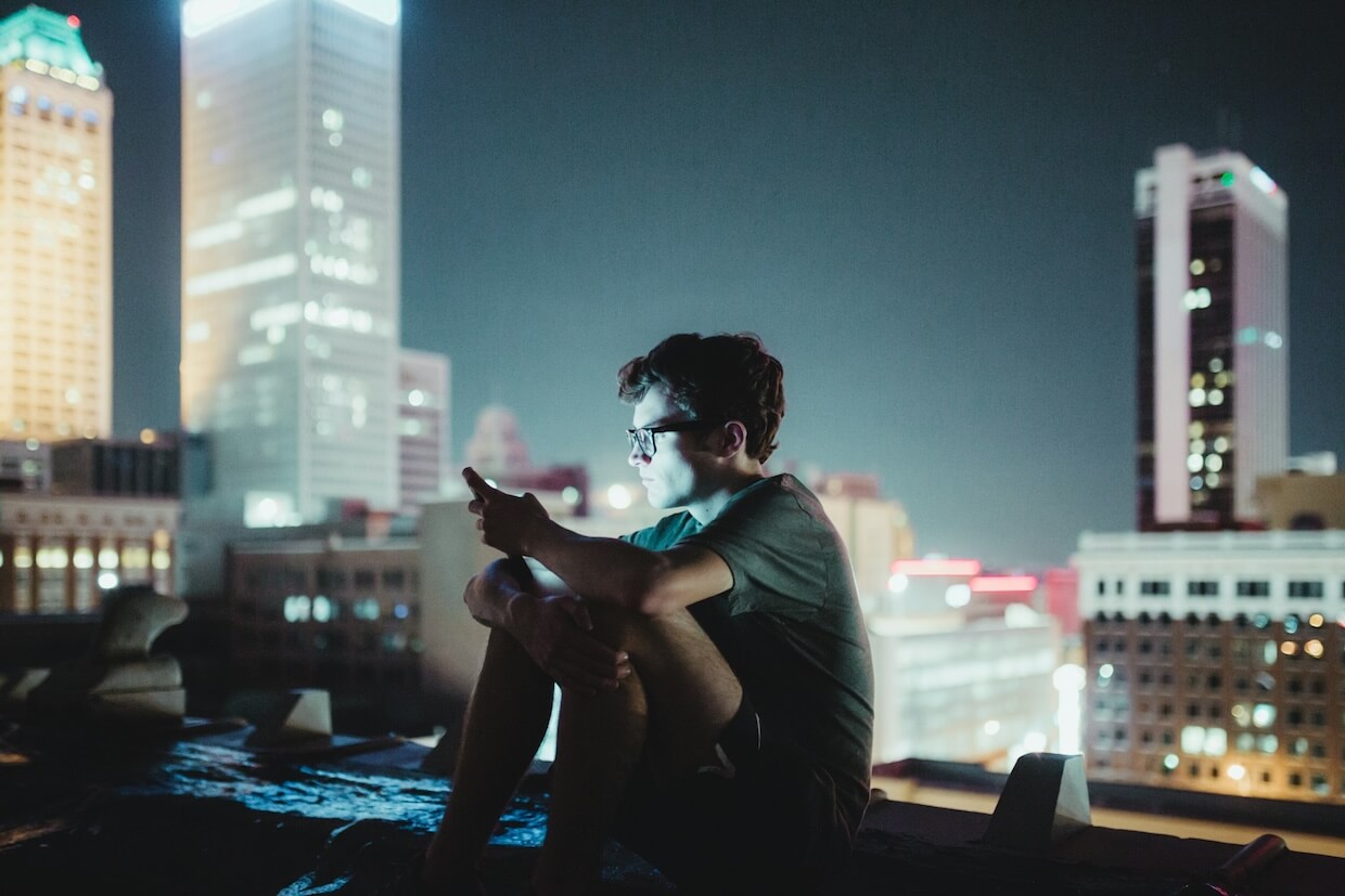 man sitting on top of building at night]