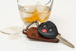 car keys next to broken glass containing alcoholic drink