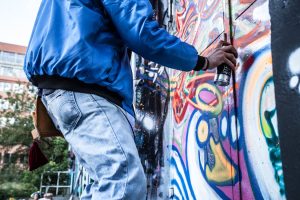 person spray painting wall