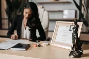 lawyer working at desk with Lady Justice statue in foreground